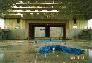 Turnhalle mit beschädigtem Dach und eingedrungenem Wasser
